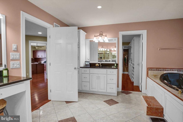 bathroom with vanity, a washtub, and tile patterned floors