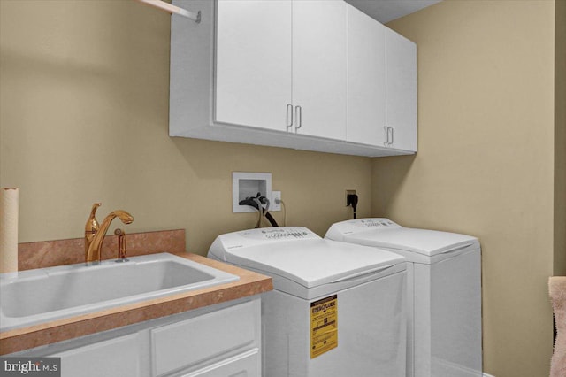 laundry room with independent washer and dryer, cabinets, and sink