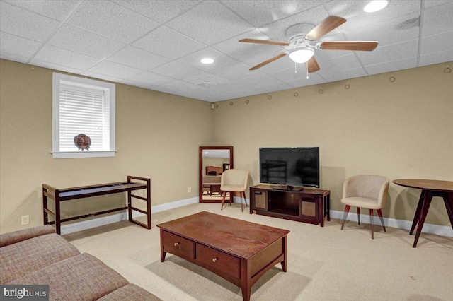 carpeted living room with ceiling fan and a paneled ceiling