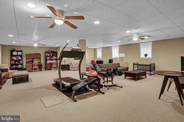 exercise room with light carpet, a paneled ceiling, and ceiling fan