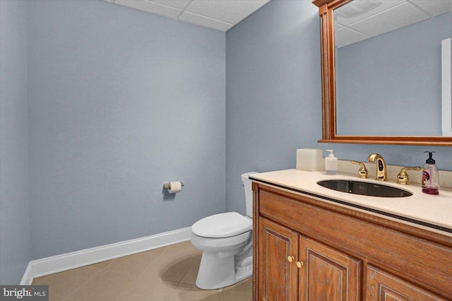 bathroom featuring vanity, a paneled ceiling, tile patterned floors, and toilet