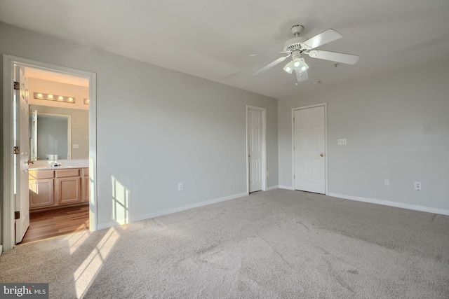 unfurnished bedroom with light carpet, ceiling fan, and ensuite bath