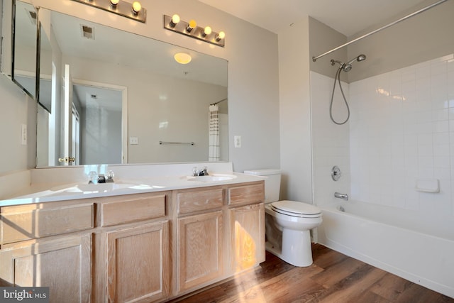 full bathroom featuring toilet, vanity, hardwood / wood-style floors, and tiled shower / bath combo