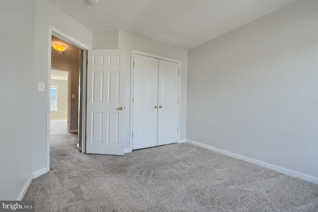 unfurnished bedroom featuring light carpet and a closet