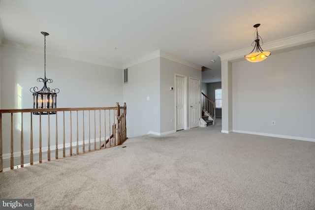 carpeted spare room with a notable chandelier and crown molding