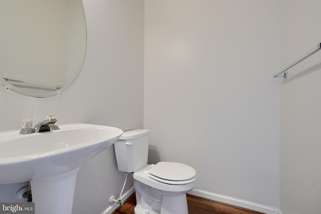 bathroom featuring wood-type flooring, sink, and toilet