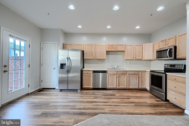 kitchen featuring sink, light brown cabinetry, stainless steel appliances, and light hardwood / wood-style flooring