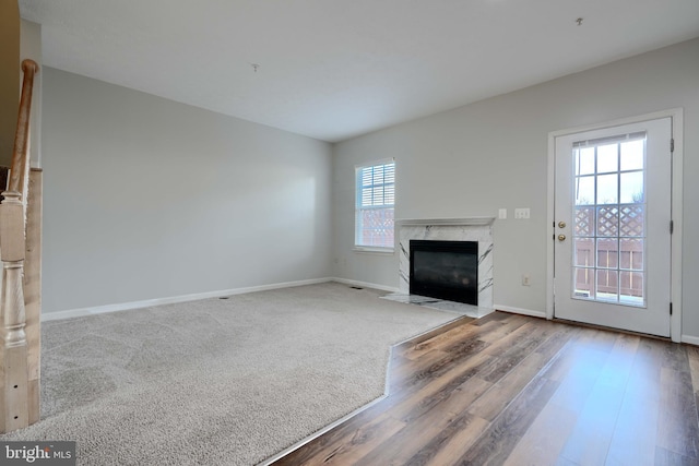 unfurnished living room with hardwood / wood-style flooring and a premium fireplace