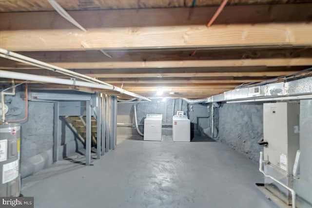 basement with electric water heater and washer and dryer