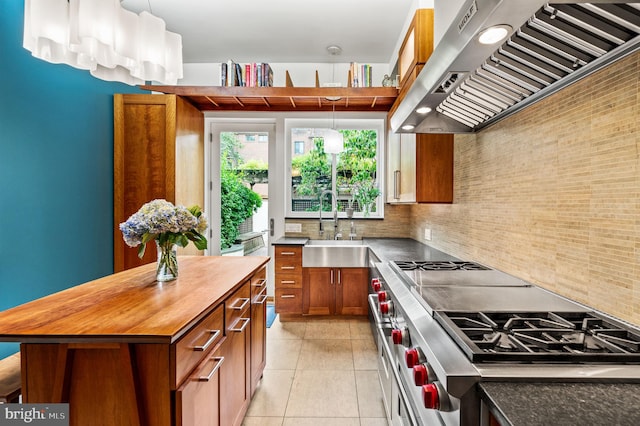 kitchen with range hood, tasteful backsplash, range with two ovens, a center island, and light tile patterned floors