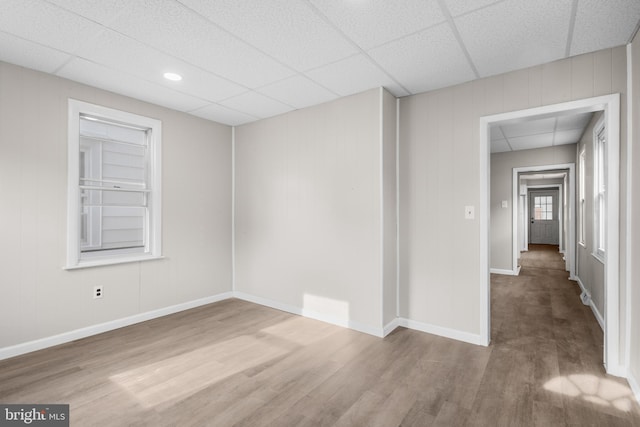 unfurnished room featuring wood-type flooring and a drop ceiling