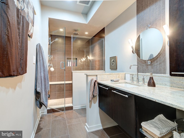 bathroom featuring vanity and a shower with door