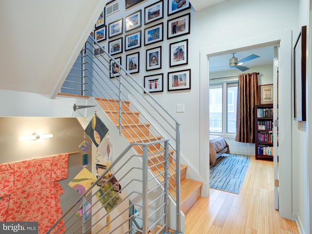 stairs featuring hardwood / wood-style flooring and ceiling fan