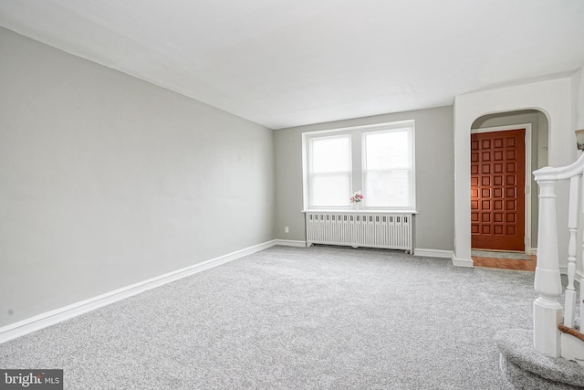 carpeted spare room featuring radiator