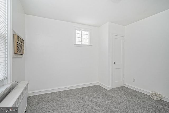 carpeted empty room featuring a wall mounted AC