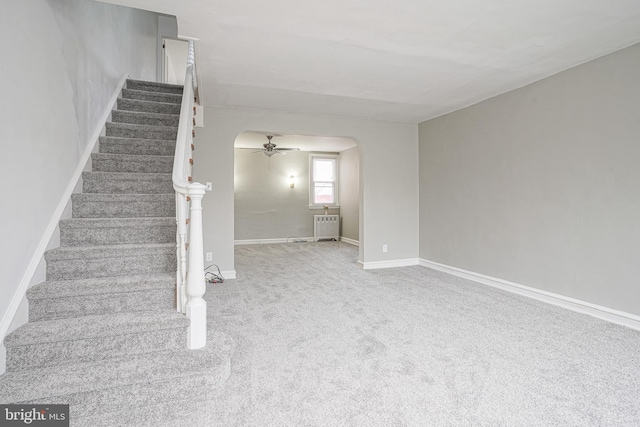 staircase featuring carpet, radiator heating unit, and ceiling fan