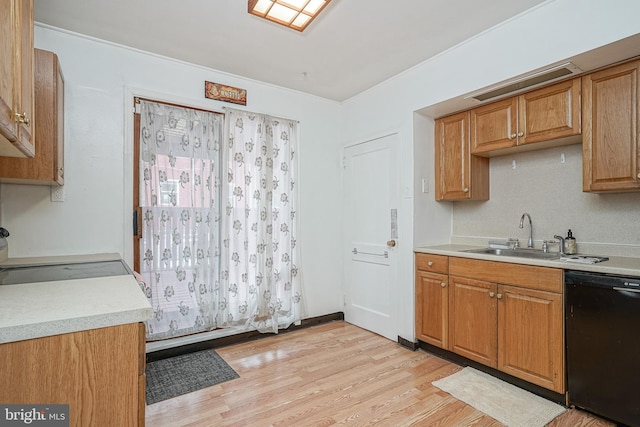 kitchen featuring dishwasher, sink, range, and light hardwood / wood-style flooring