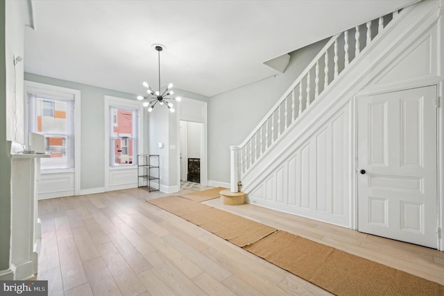 unfurnished living room featuring light hardwood / wood-style flooring and a chandelier