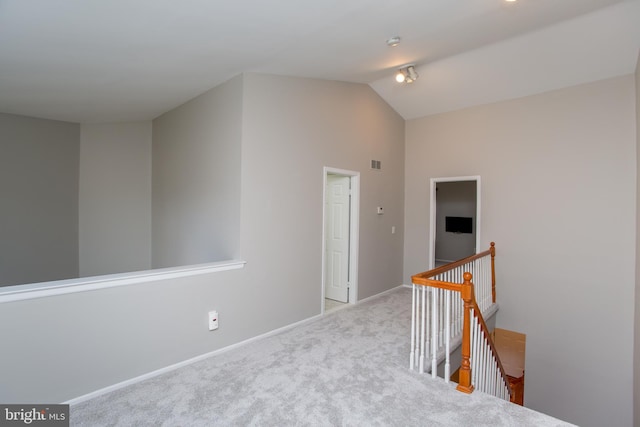 hall with light carpet and vaulted ceiling