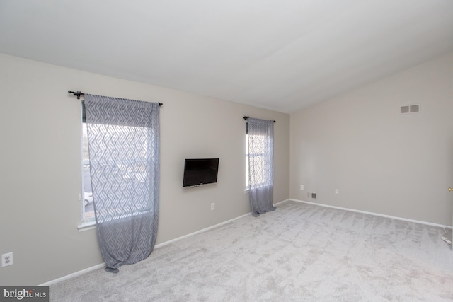 unfurnished living room featuring light carpet and vaulted ceiling