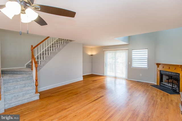 living room featuring ceiling fan, a fireplace, and hardwood / wood-style floors