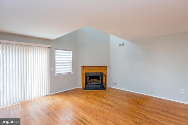 unfurnished living room featuring vaulted ceiling and light wood-type flooring