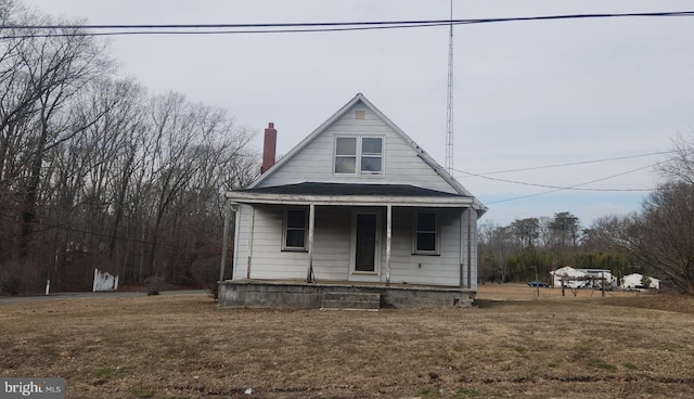 bungalow featuring covered porch and a front yard