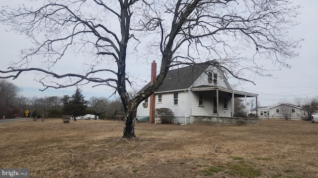 view of home's exterior with a porch and a lawn