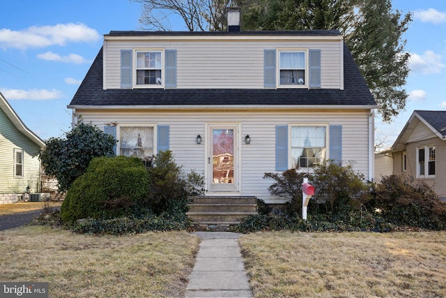 view of front of home featuring central AC unit and a front yard