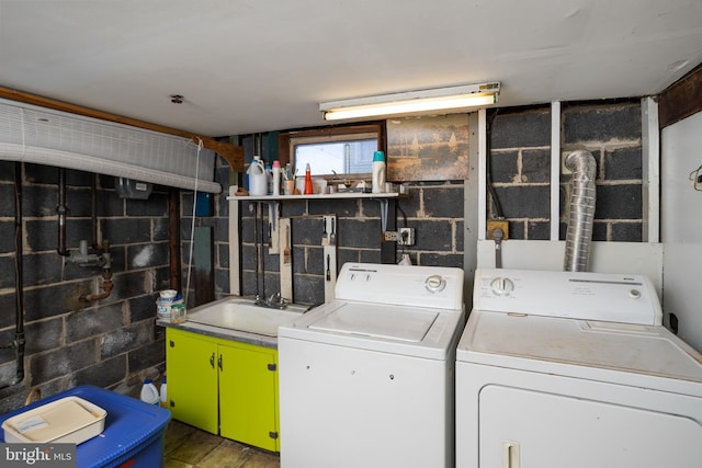 clothes washing area featuring wood-type flooring, separate washer and dryer, and sink