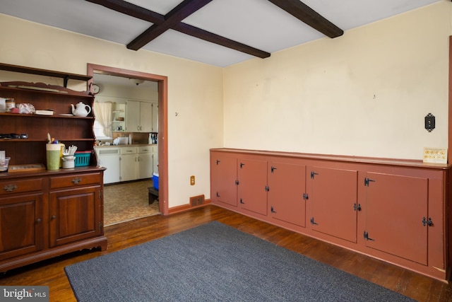 interior space featuring beam ceiling and dark wood-type flooring