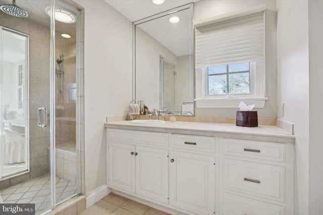 full bathroom featuring baseboards, a shower stall, vanity, and tile patterned floors