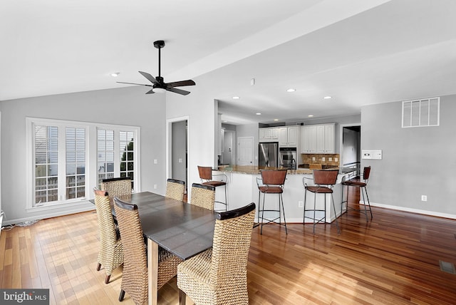 dining room with lofted ceiling, light hardwood / wood-style floors, and ceiling fan