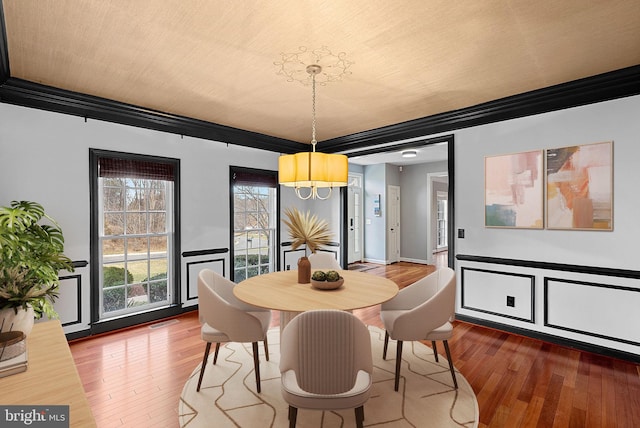 dining space featuring crown molding and wood-type flooring