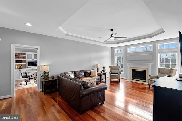 living room with hardwood / wood-style flooring, a raised ceiling, and a wealth of natural light