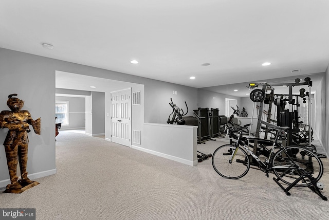 exercise room featuring light carpet