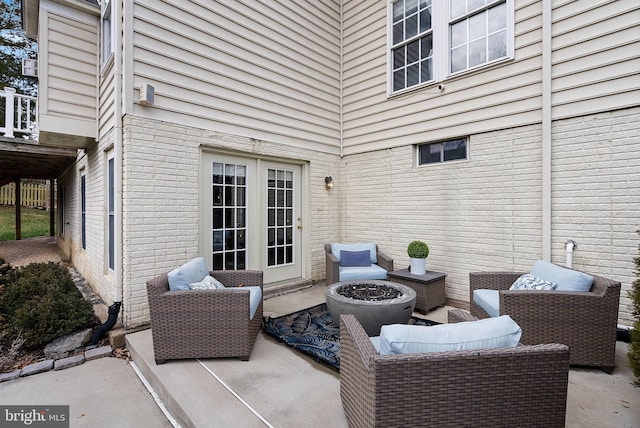 view of patio / terrace featuring an outdoor living space with a fire pit and french doors