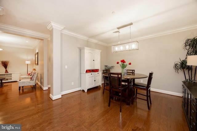 dining space with dark wood-type flooring, baseboards, and ornate columns