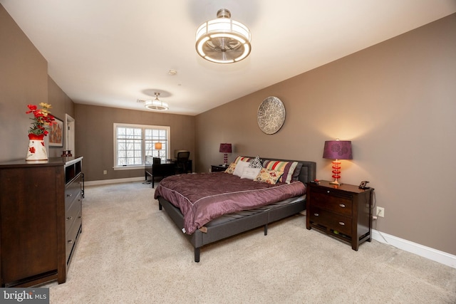 bedroom featuring light carpet and baseboards