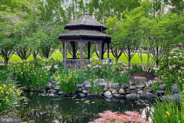 view of community featuring a garden pond and a gazebo