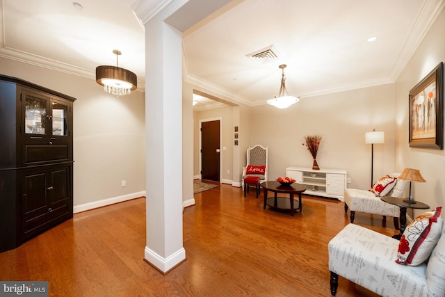 sitting room featuring visible vents, crown molding, baseboards, and wood finished floors