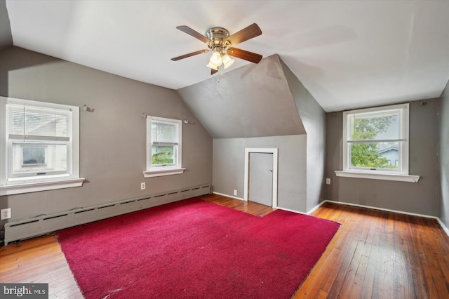 bonus room with a baseboard radiator, lofted ceiling, and light hardwood / wood-style flooring