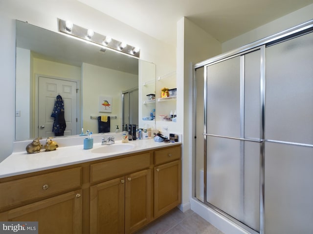 bathroom with tile patterned flooring, vanity, and a shower stall