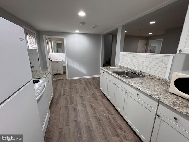 kitchen featuring sink, white appliances, white cabinetry, wood-type flooring, and light stone countertops