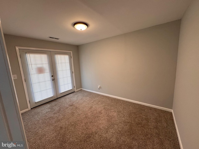 empty room featuring french doors and carpet floors