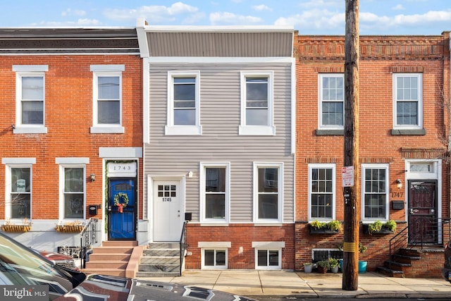 view of property featuring entry steps and brick siding