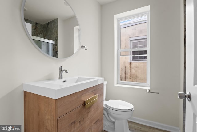 full bathroom with toilet, baseboards, and vanity