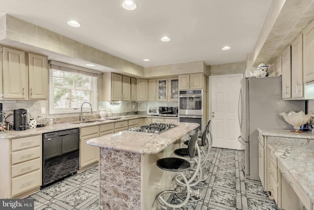 kitchen with sink, a breakfast bar area, backsplash, a center island, and stainless steel appliances