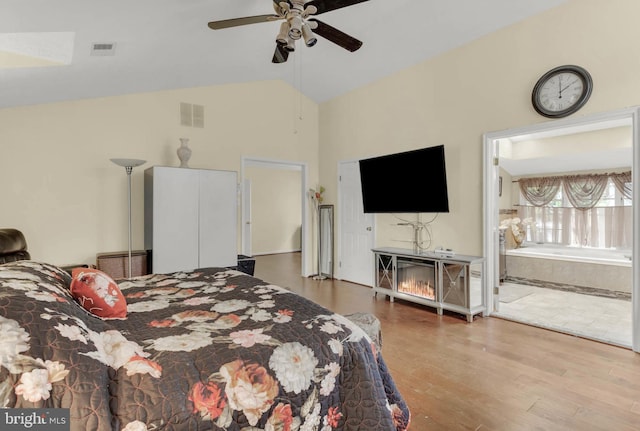 bedroom with vaulted ceiling, wood-type flooring, ensuite bathroom, and ceiling fan