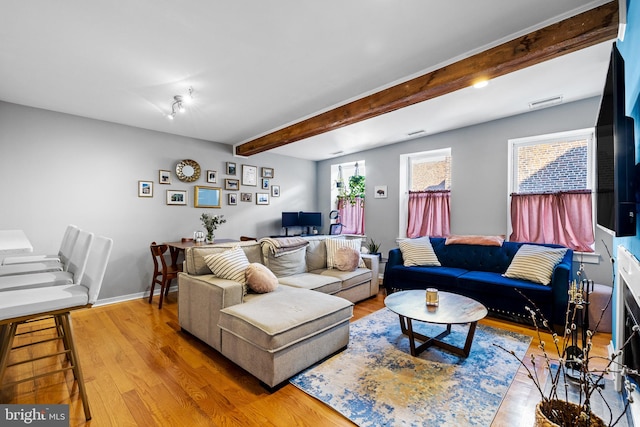 living room featuring wood-type flooring and beam ceiling